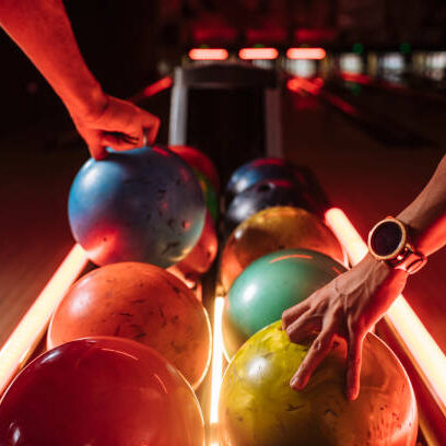 Bowling players picking up balls from the rack